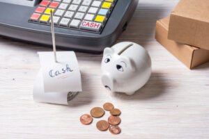 Business bank account concept. A piggy bank and coins next to a calculator on a desk.
